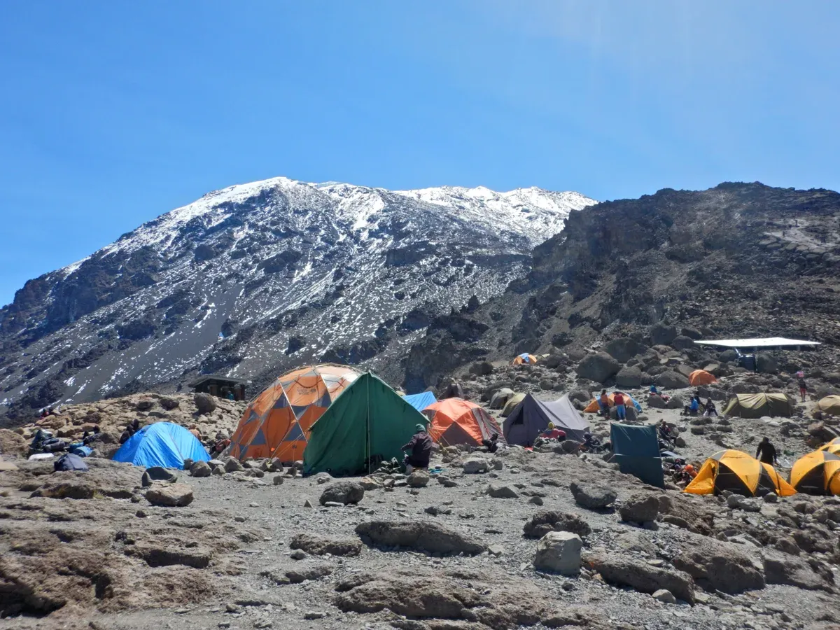 Tents at Barafu Camp below the snowy summit cone, the start of summit night on Kilimanjaro climbing tours