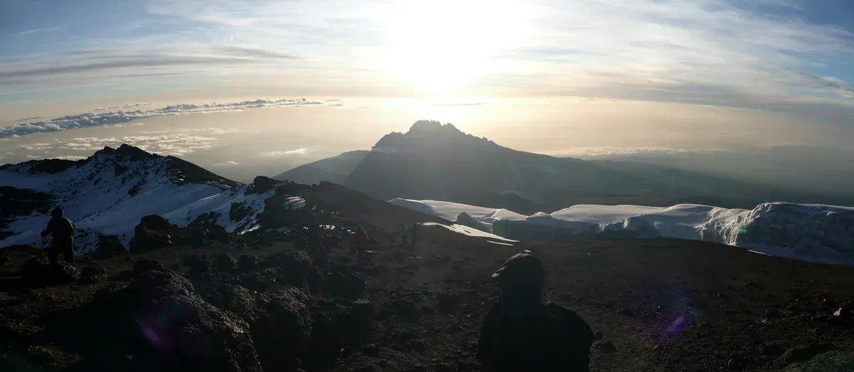 The jagged cone of Mawenzi at sunrise seen from the crater rim, the view at the end of summit night on Kilimanjaro climbing tours